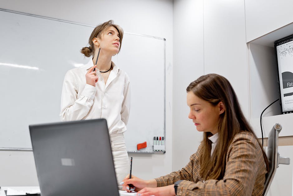 Two female coworkers collaborate in a creative workplace, exchanging ideas in a modern office.