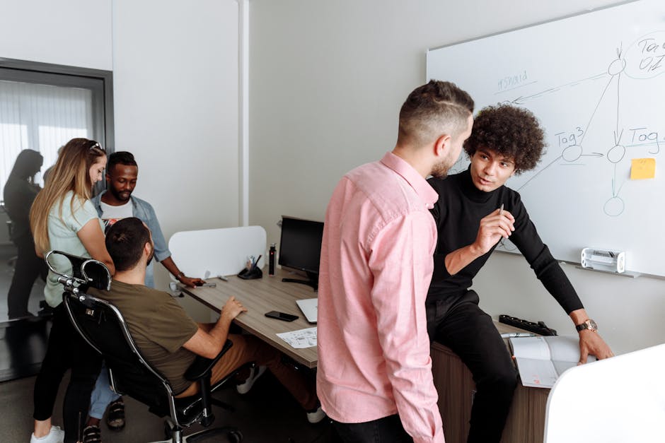 Diverse team engaged in productive office discussion, sharing ideas on a project.